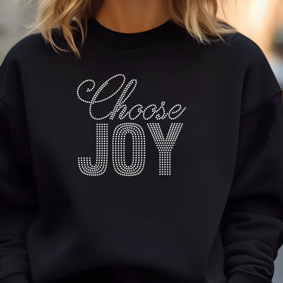 Woman wearing a black crewneck sweatshirt that reads Choose Joy in crystal rhinestones